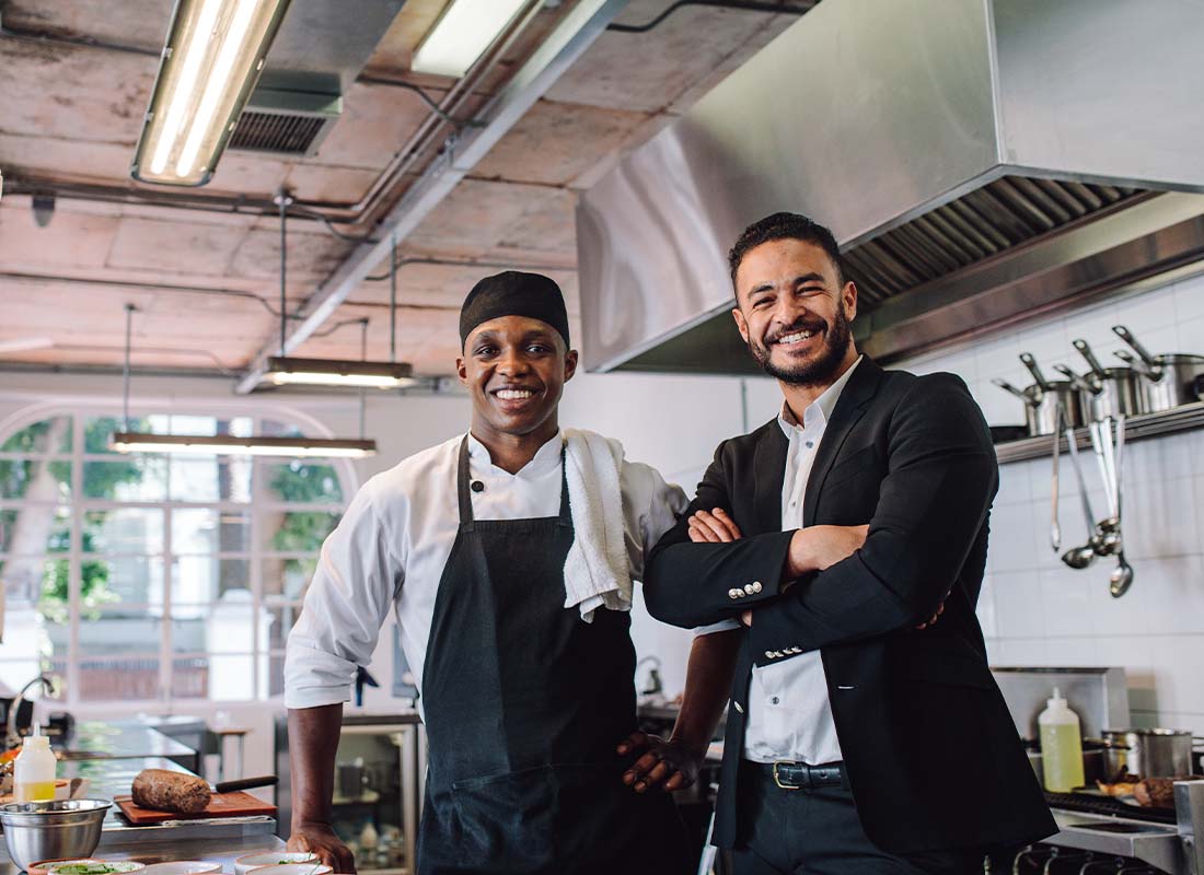 Restaurant Insurance - Portrait of a Happy Restaurant Owner and Chef in the Kitchen of a Brand New Establishment